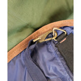 Bronze metal carabiner attached to blue nylon strap and olive green edge on perf combo 0g lightweight turnout rug