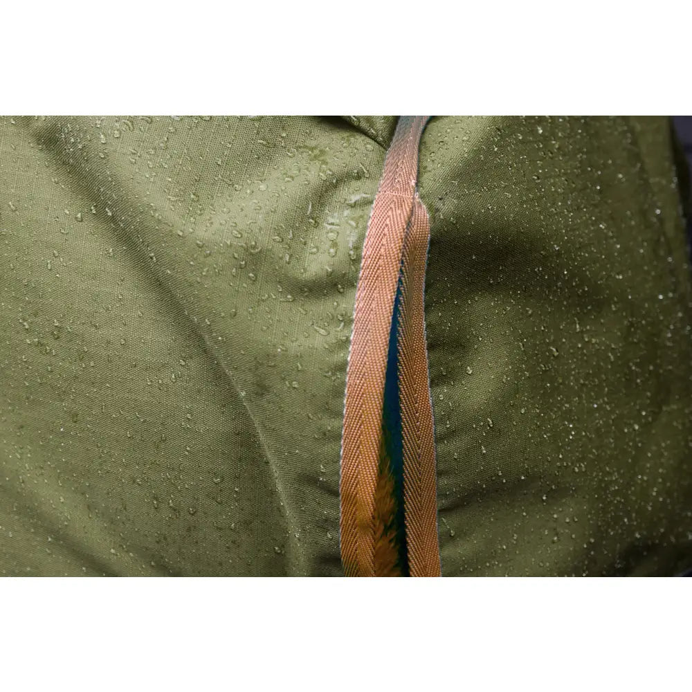 A brown woven strap with sheen on olive green fabric with water droplets on the perf combo 0g lightweight turnout rug