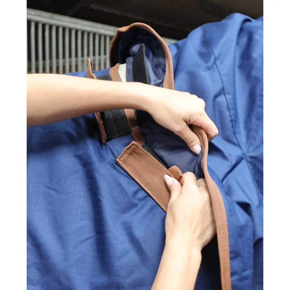 Blue canvas tote bag with brown leather straps shown alongside perf detachable neck 100g lightweight turnout rug for horses