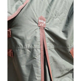 A dusty rose detachable neck drawstring and tag on an olive green perf detachable neck turnout rug for horses