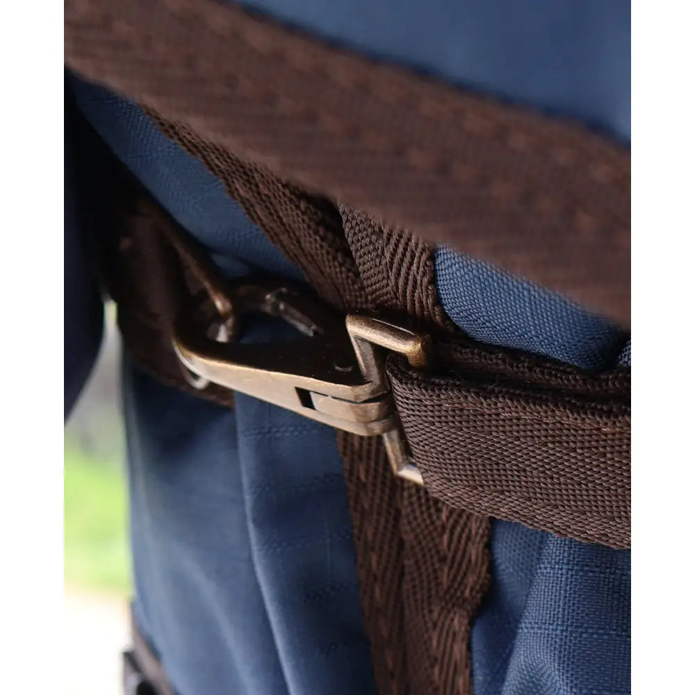Brown woven strap with metallic buckle on blue fabric of perf detachable neck turnout rug for horses