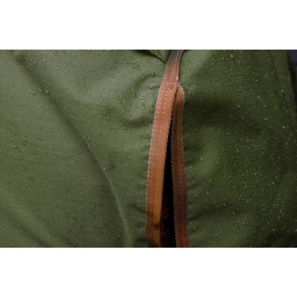 A brown textured zipper on dark green water-resistant fabric of the perf standard 0g lightweight turnout rug for horses