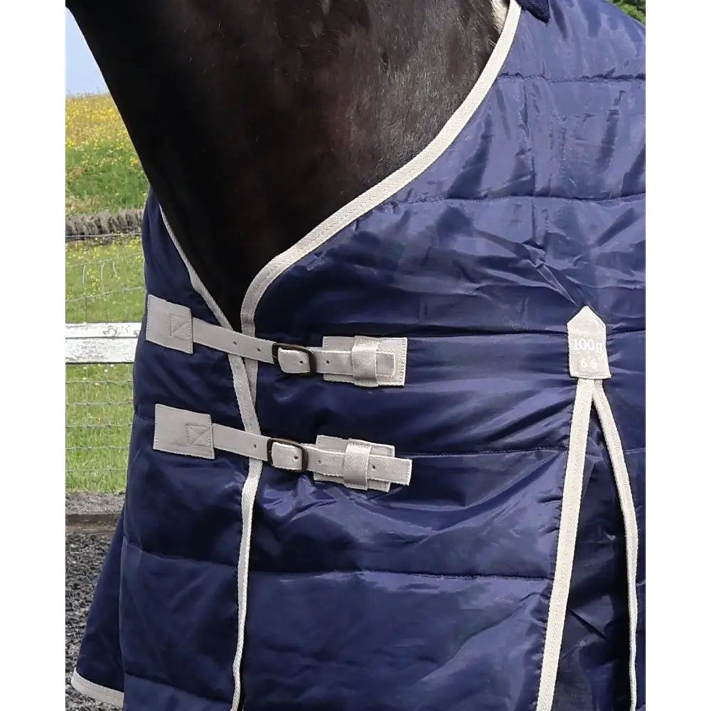 Navy blue quilted perf standard 100g light stable rug for horses with silver buckles and white trim