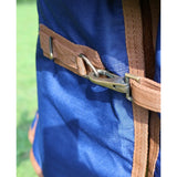 Blue canvas backpack with tan webbing straps and brass buckle shown with perf standard 100g lightweight turnout rug