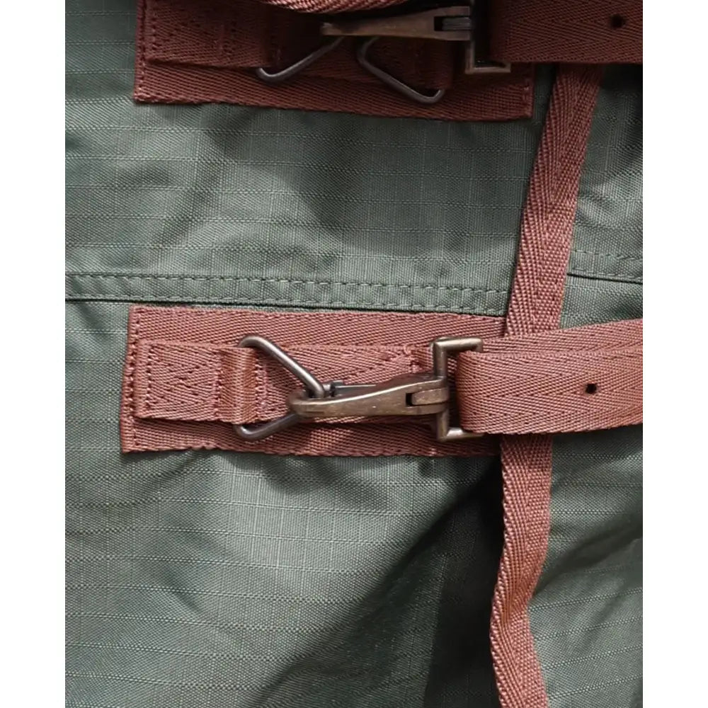 Rust-colored webbing strap with metal buckle and loop on the back of perf standard 100g lightweight turnout rug