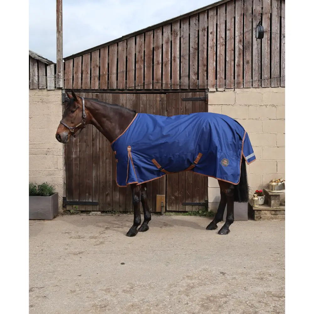 Navy blue perf standard 100g turnout rug with tan leather straps and embroidered logo for lightweight protection