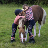 Brown and white pony with children in colorful clothes, showcasing Pony Passion head collar and lead rope