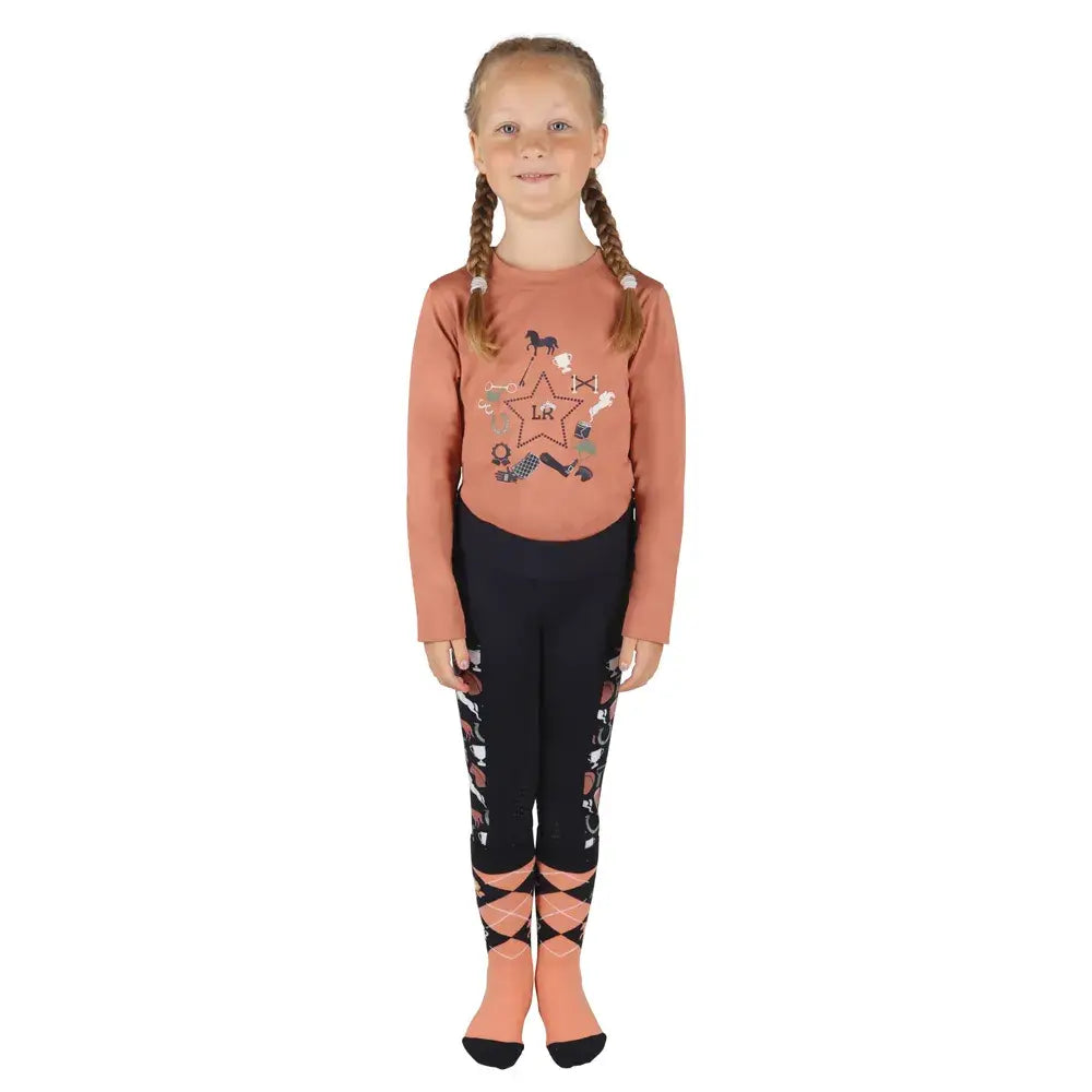 A young girl wearing a rust pony passion motif long sleeve top with star elbow patched and black leggings with diamond accents