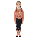 A young girl wearing a rust pony passion motif long sleeve top with star elbow patched and black leggings with diamond accents