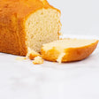Golden brown pound cake loaf with soft pale interior and crumbly texture like round white bread or white bread