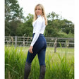Navy blue premier equine alexa ladies riding tights with technically advanced four-way stretch worn with white top and black boots