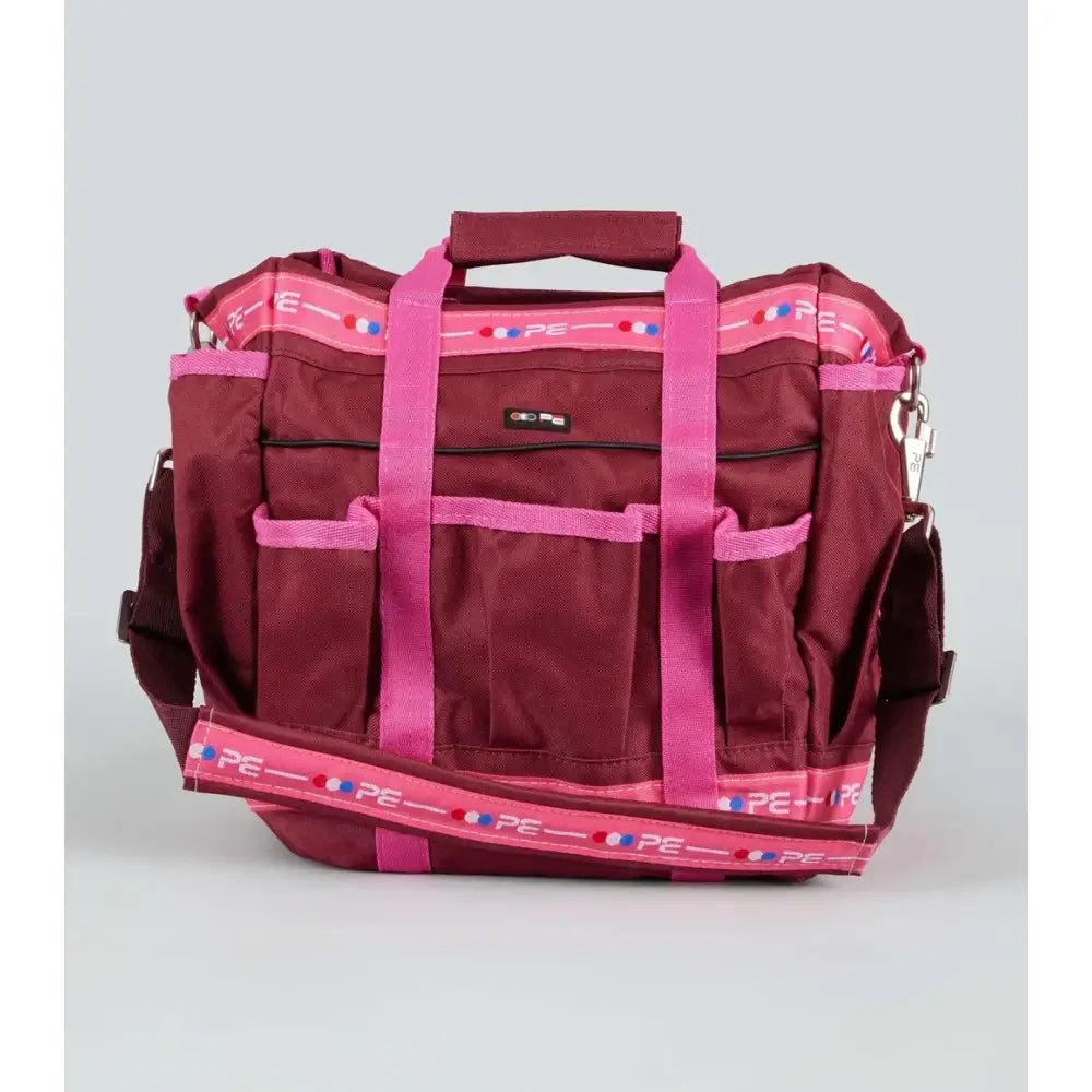 Maroon and pink premier equine grooming kit bag with multiple pockets and adjustable straps for easy use