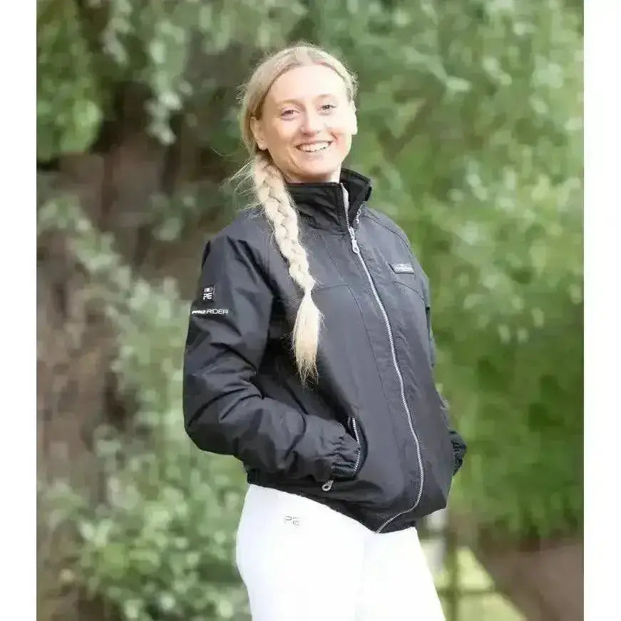 Black waterproof riding jacket with silver zipper and premier equine pro rider unisex logo on sleeve