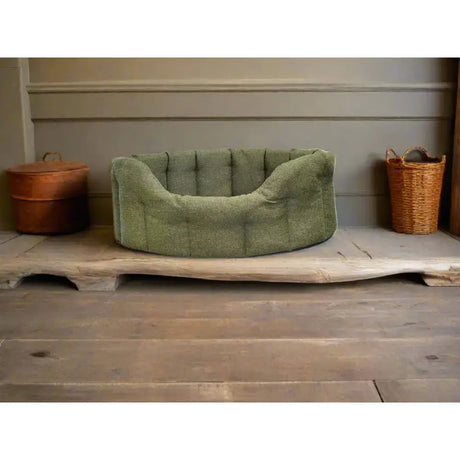 A plush olive-green premium orkney tweed tweed oval bed with soft fabric rounded edges and a 7cm base