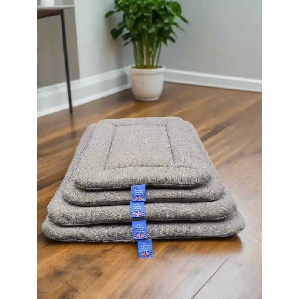 Stack of four gray textured premium orkney tweed rectangular pet mats with blue union jack tags by p&l country dog beds