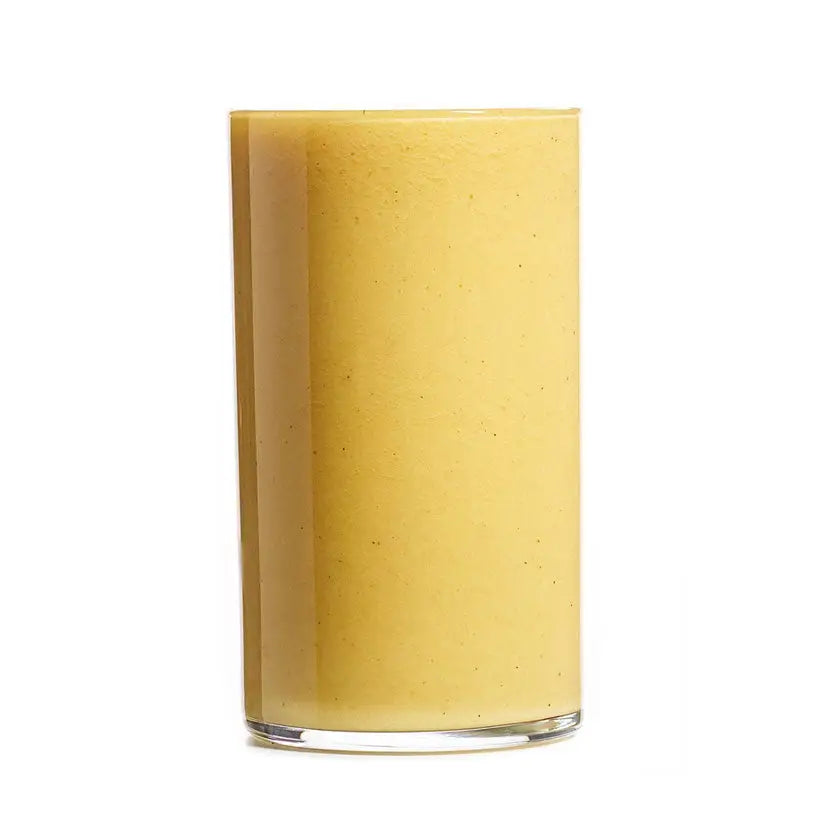 A tall clear glass filled with creamy yellow projuice coconut crush smoothie perfect for barnstaple equestrian fans