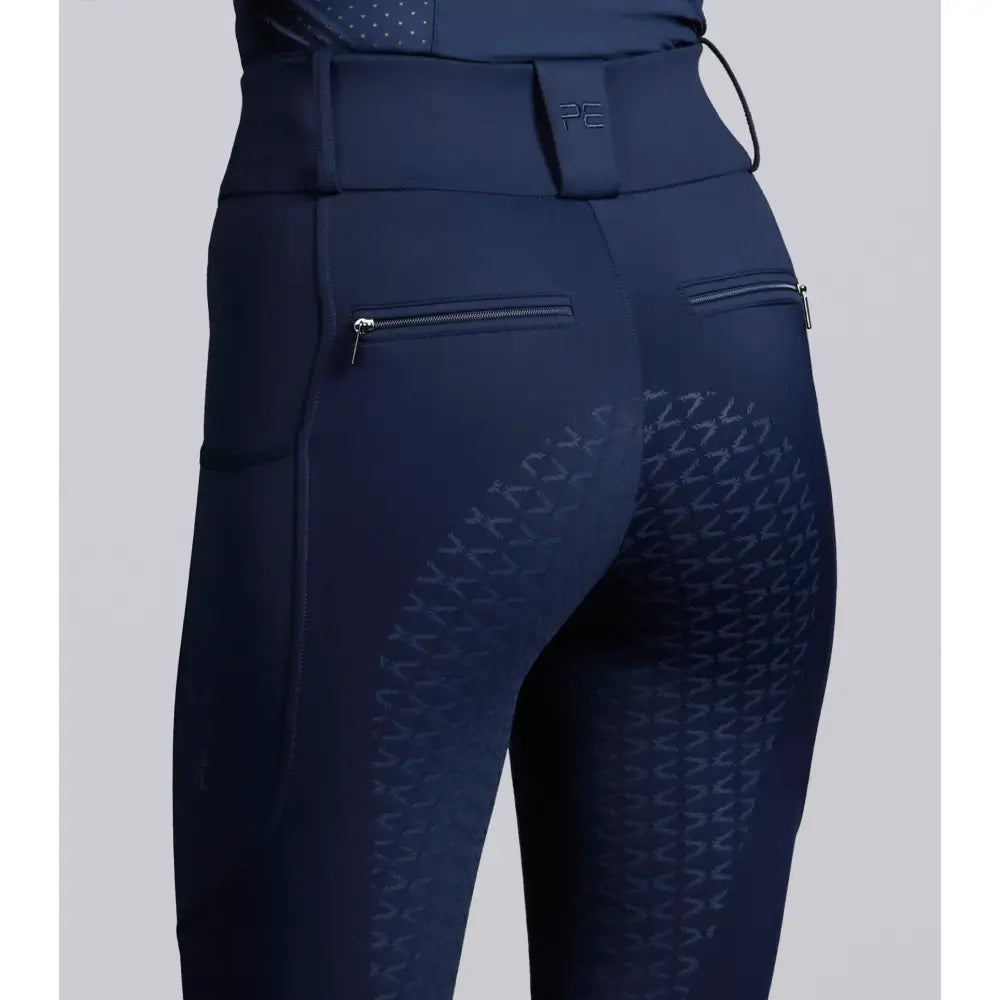 Navy blue prospero riding tights with subtle thigh texture and zippered side pockets for performance riding