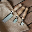 Three wooden-handled metal pet dander combs in varying sizes for smart grooming quarter and quarter marking comb use