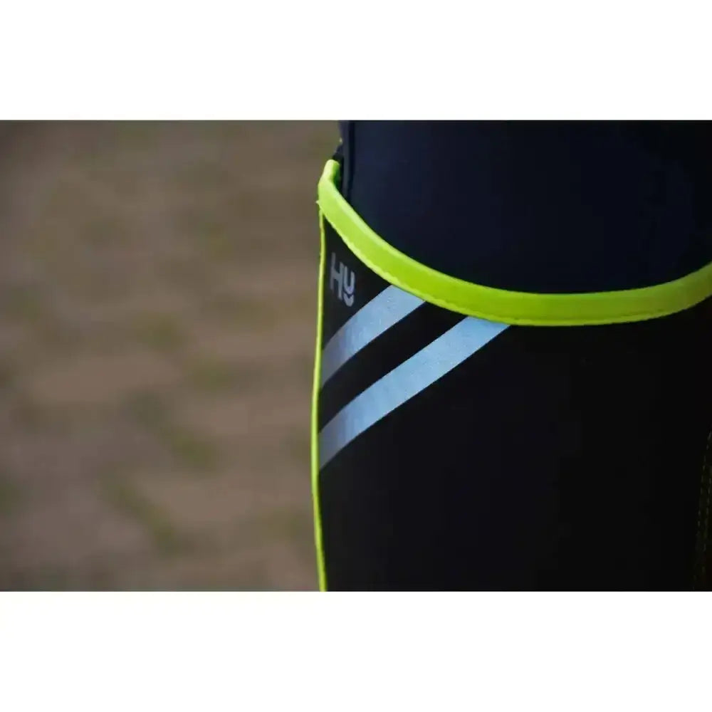 Black reflector half chaps with bright neon green elastic waistband and two silver reflective stripes by hy equestrian