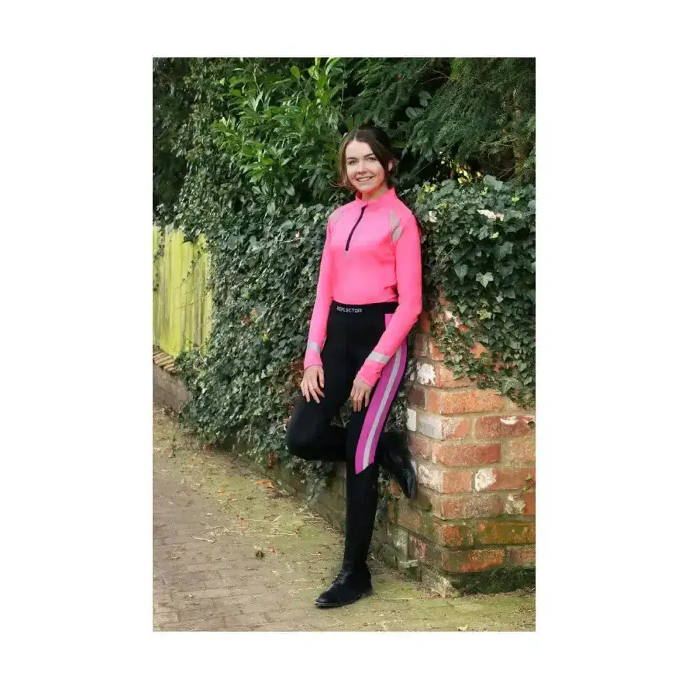 A vibrant pink long-sleeved top with reflective gray panels paired with black reflector riding tights with magenta stripes