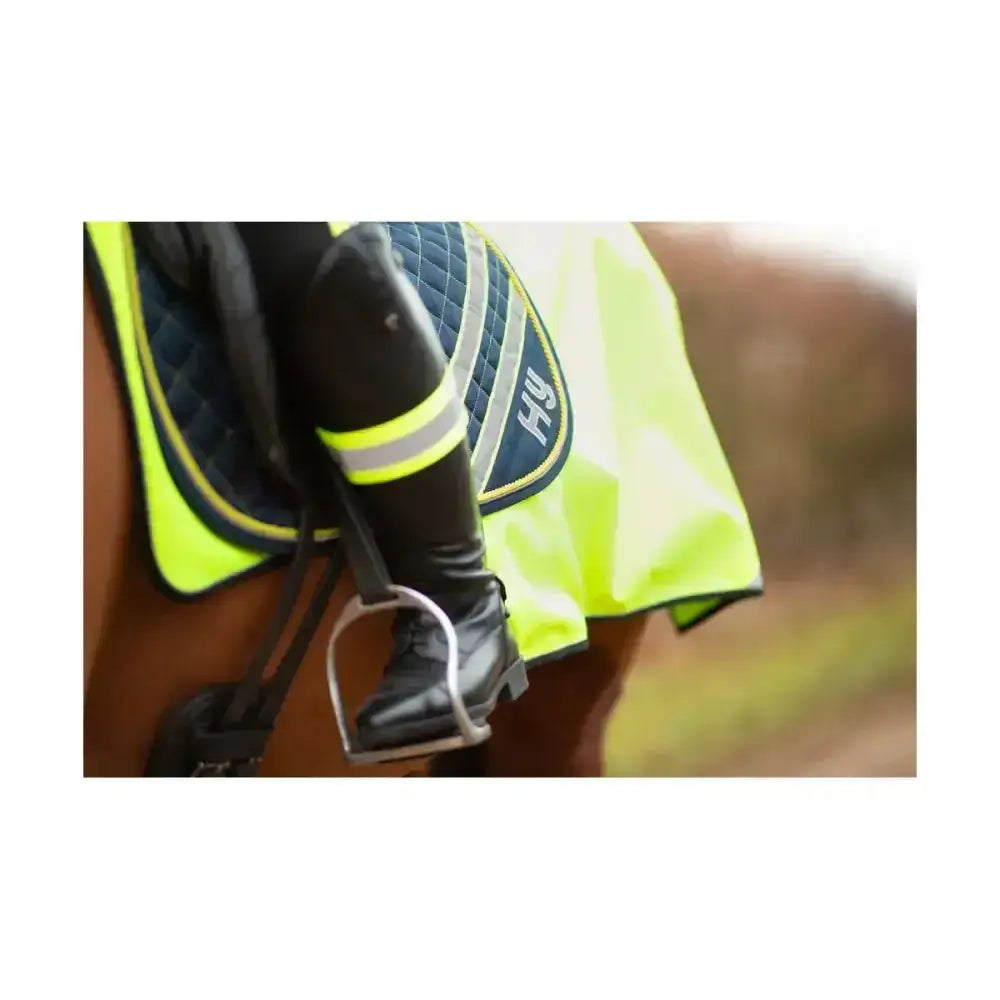 Bright neon yellow reflector saddle pad hy equestrian with black quilted panel and reflective stripes on horse back