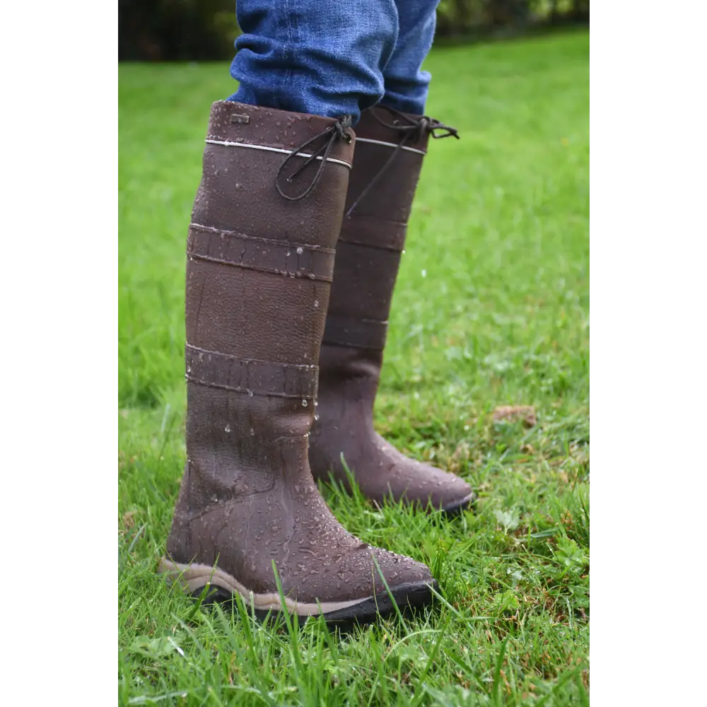 Pair of tall brown Rhinegold Harlem Leather Waterproof Country Boots on grass