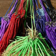 Colorful braided rope bundles with metallic rings on straw for rhinegold horsehage nets horse feeding solution