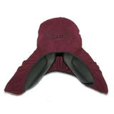 Maroon suede rhinegold stretchy saddle cover with black lining and subtle brand embroidery for equestrian use