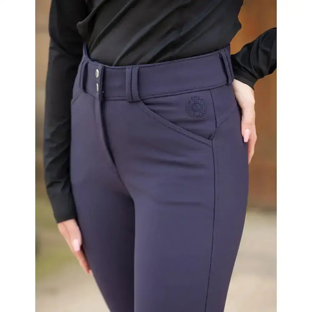 Navy blue rhinegold waterproof breeches with a fitted silhouette high waistband and subtle embroidered logo on front pocket