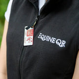 Black fleece rider emergency tag vest with white equine qr embroidery and red and white emergency contacts tag on zipper