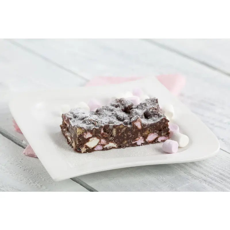 A square slice of chocolate rocky road with pink and white marshmallows dusted with powdered sugar made with wheat flour and invert sugar syrup