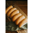 Golden-brown ryders bakery white finger rolls with soft texture on wooden board perfect for sandwiches or sides