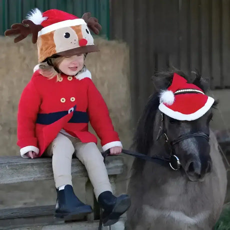 A child wearing a red and brown santa horse hat bonnet with antlers white fur trim and red nose by equetech