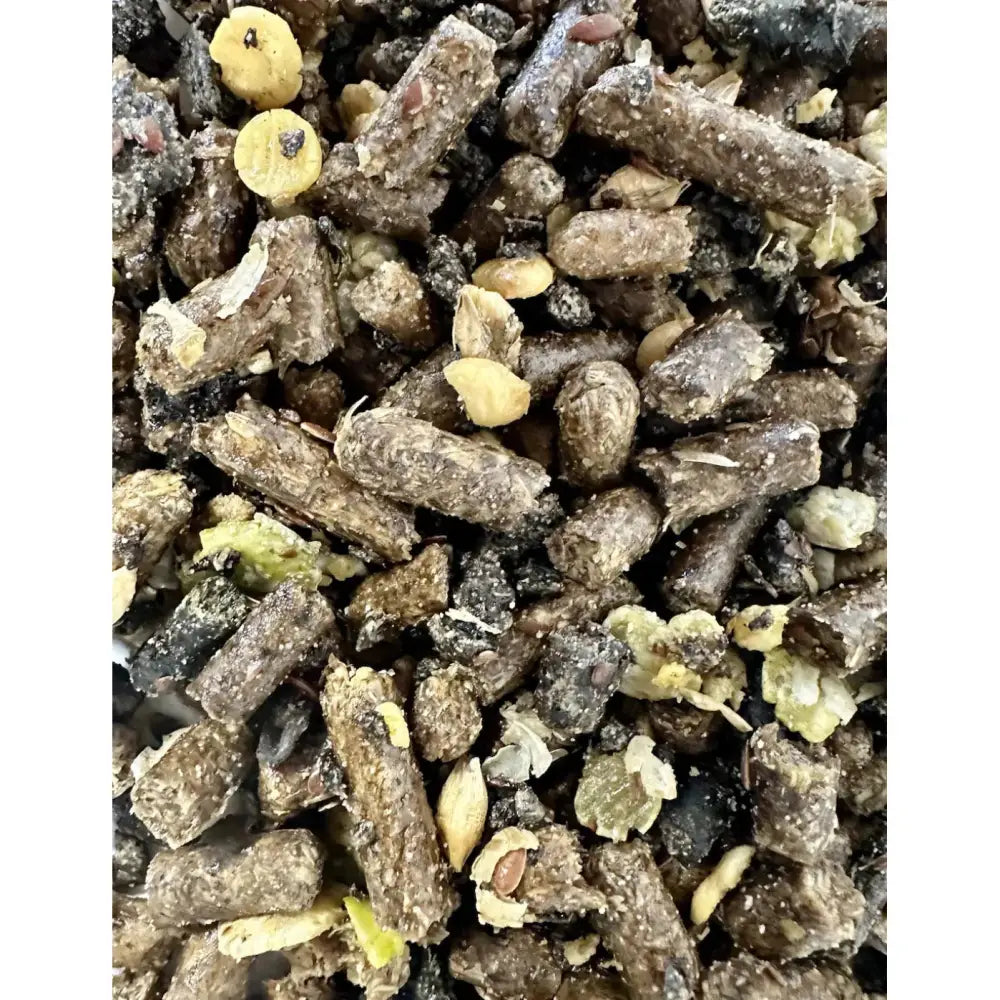 A mix of dark brown and black pelletized saracen veteran balancer animal feed with scattered yellow seeds and low glycaemic coating