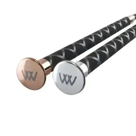 Two woof wear harmony dressage whips with black textured handles and rose gold and silver caps for schooling use