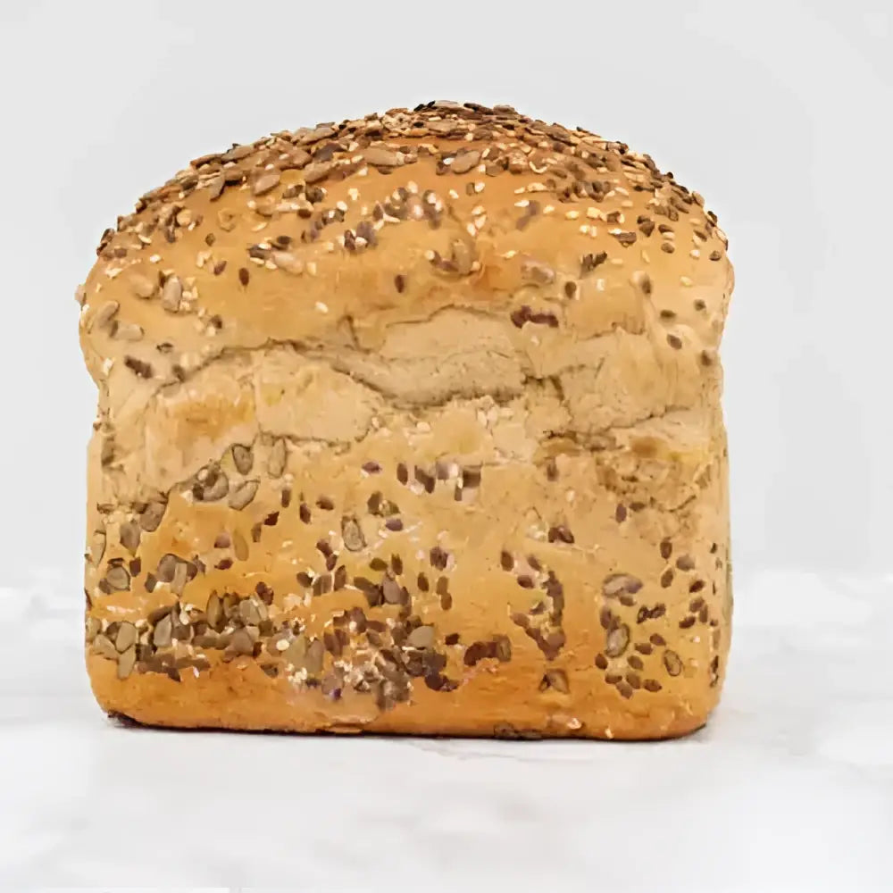 Golden brown seeded rye bread round loaf topped with sesame and dark seeds perfect for sandwiches or toast
