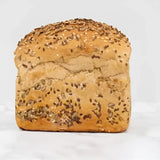 Golden brown seeded rye bread round loaf topped with sesame and dark seeds perfect for sandwiches or toast