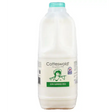 A white plastic bottle of cotteswold semi skimmed milk with a teal cap and green vintage label