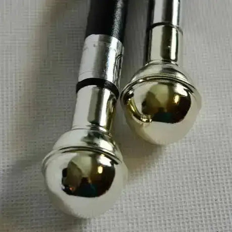 Two metallic showing cane chrome ball walking canes with black leather handles and silver leather covered shank joints