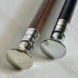 Two elegant handmade showing canes with cane chrome flat tops, leather grips in brown and black, and silver caps
