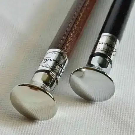Two elegant handmade showing canes with cane chrome flat tops, leather grips in brown and black, and silver caps