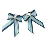A pair of navy and light blue showquest piggy bows with silver glitter accents on black elastics for a finishing showring touch