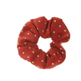 A red fabric showquest scrunchie lurex spot with small gold polka dots for stylish hair styling