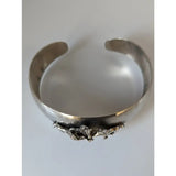 Silver steed herd bangle featuring a silver cuff with hammered finish and detailed 3d sculpted horse figures