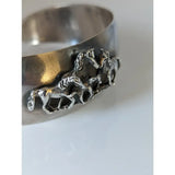 Silver steed herd bangle is a silver horse-themed cuff bracelet with a hammered finish perfect for equestrian jewelry fans
