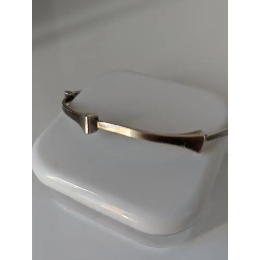 A sleek gold-tone metal bangle with a modern geometric design from silver steed hoofnails bangle collection