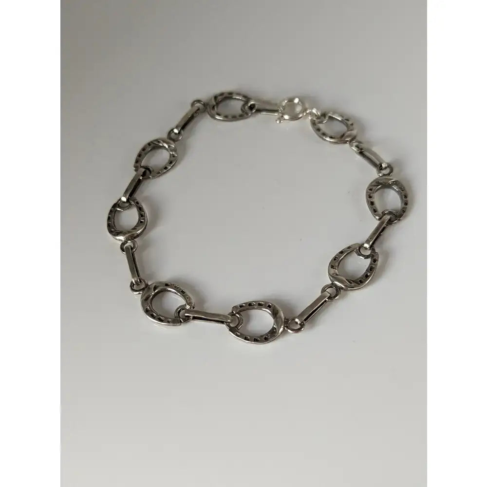 Silver steed horseshoe silver bracelet with polished metallic finish and detailed nailhead texture on horse hoof links