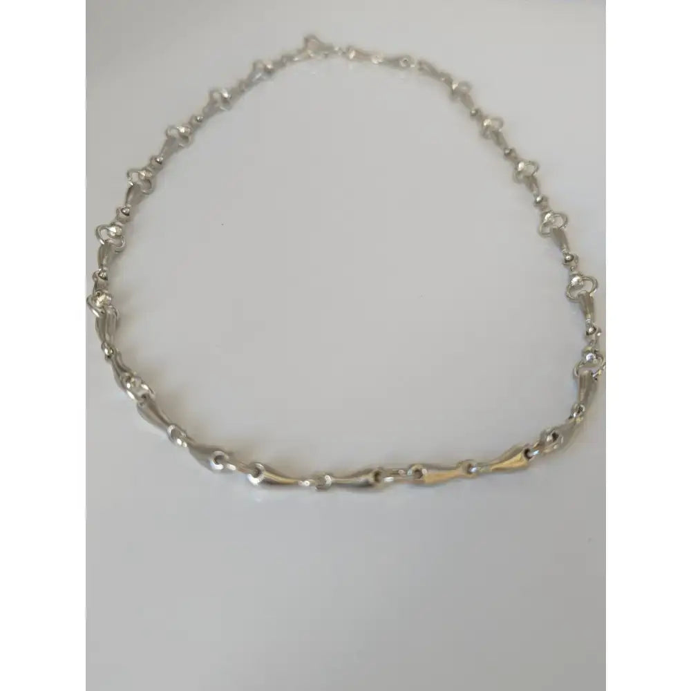 Silver steed snaffle necklace with silver and gold-tone chain and distinctive articulated equestrian link design