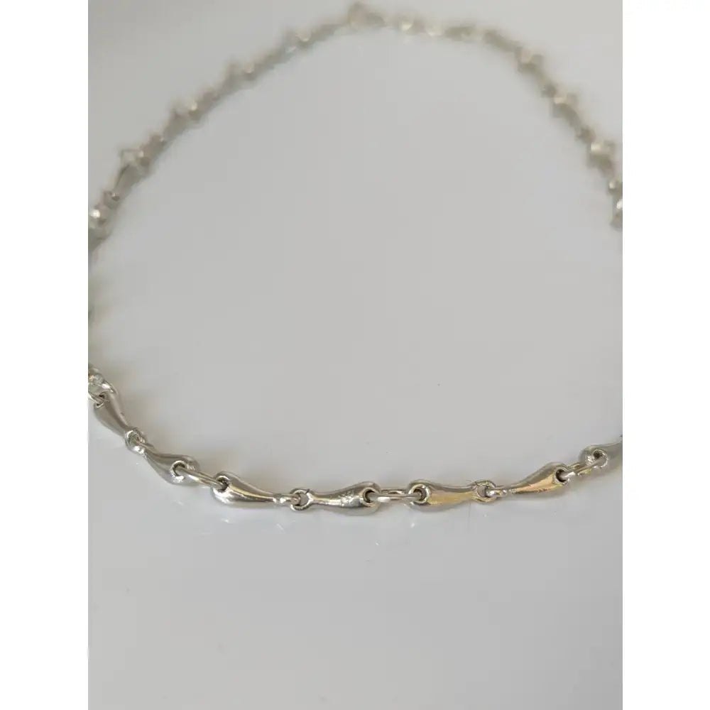 Silver steed snaffle necklace featuring a sleek silver and gold-tone chain with interlocking links for equestrian style