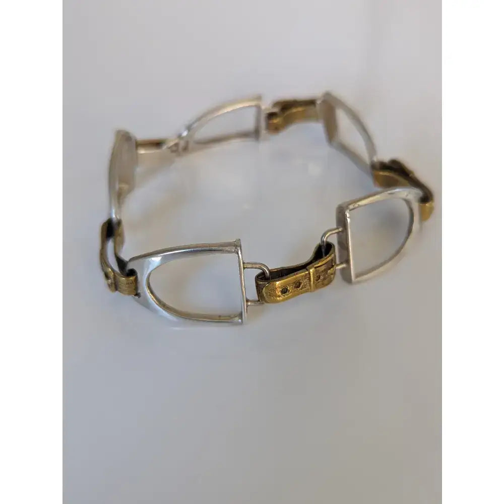 Silver steed stirrups bracelet in silver and gold tone with polished metallic finish and equestrian design